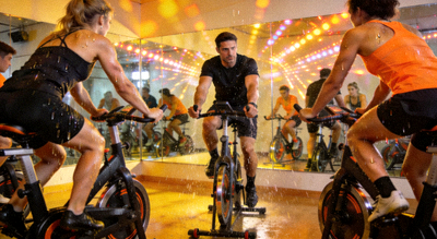 动感单车课程，学员在教练带领下进行室内骑行训练，氛围热烈